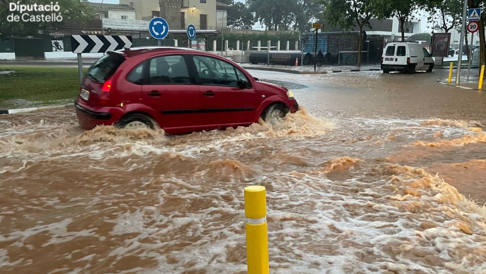 Un cotxe circula per una rotonda inundada en Castelló