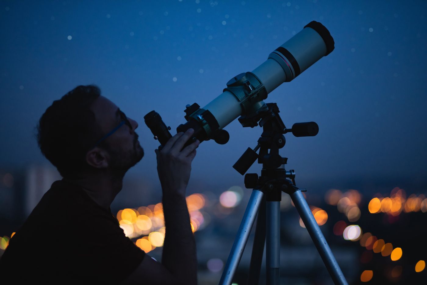 Una persona observa el cel amb un telescopi 