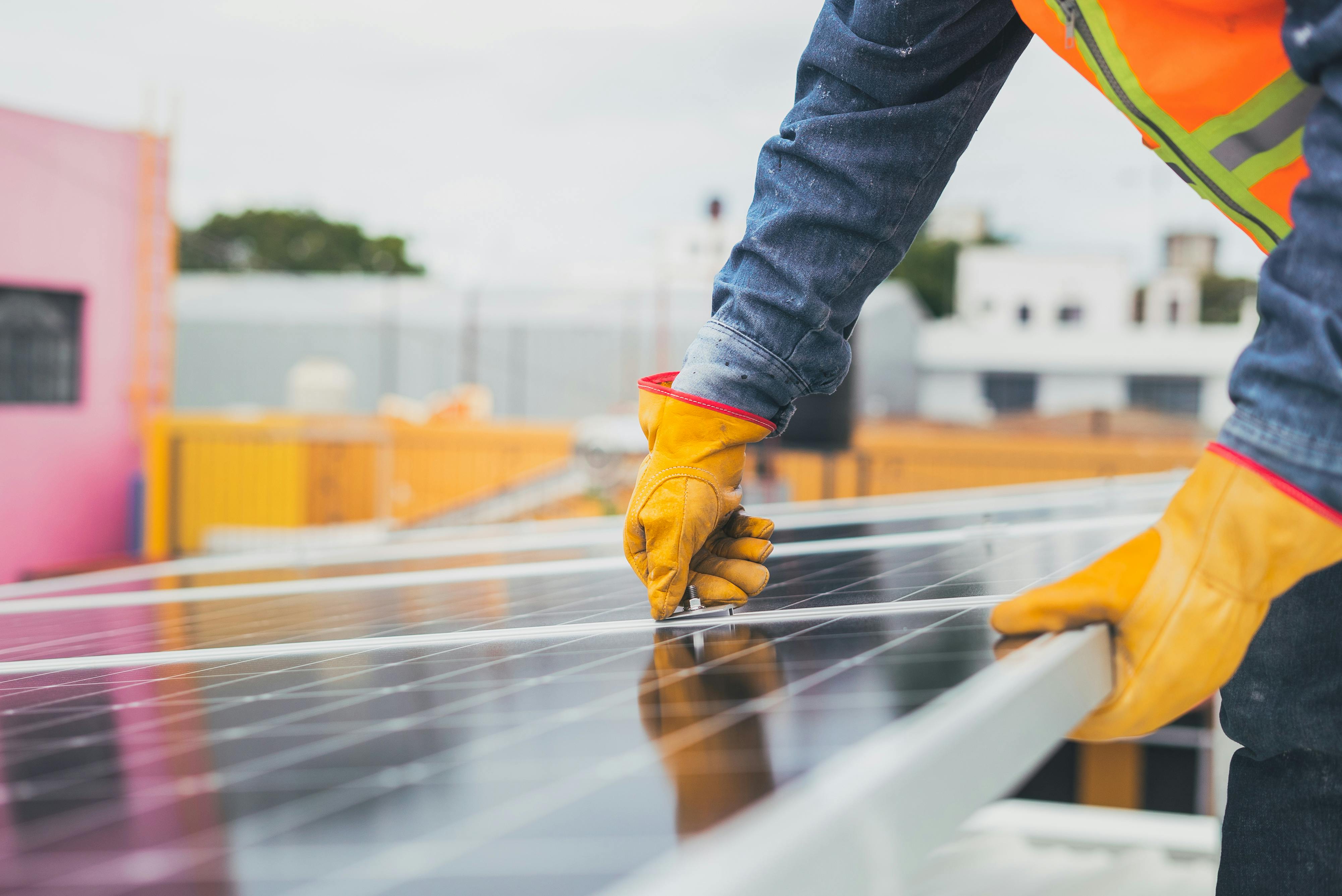 Un operari instal·la una placa solar