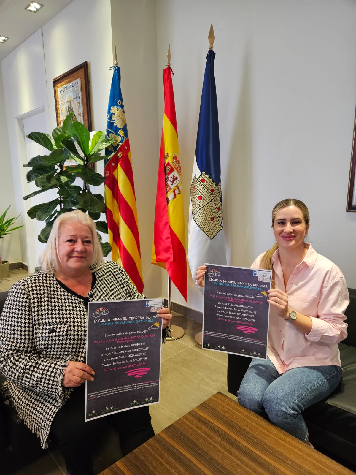 L'alcaldessa i la regidora d'Educació amb el cartell de l'escola infantil