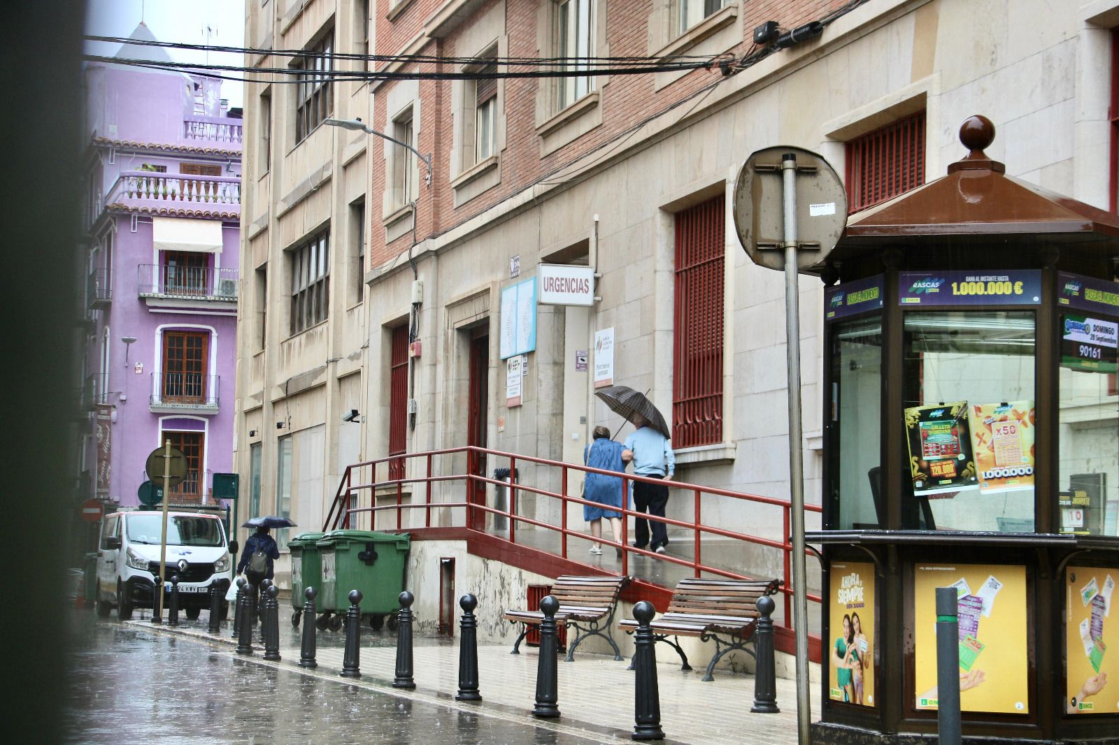 Unas personas accediendo al Centro de Especialidades Jaume I un día de lluvia