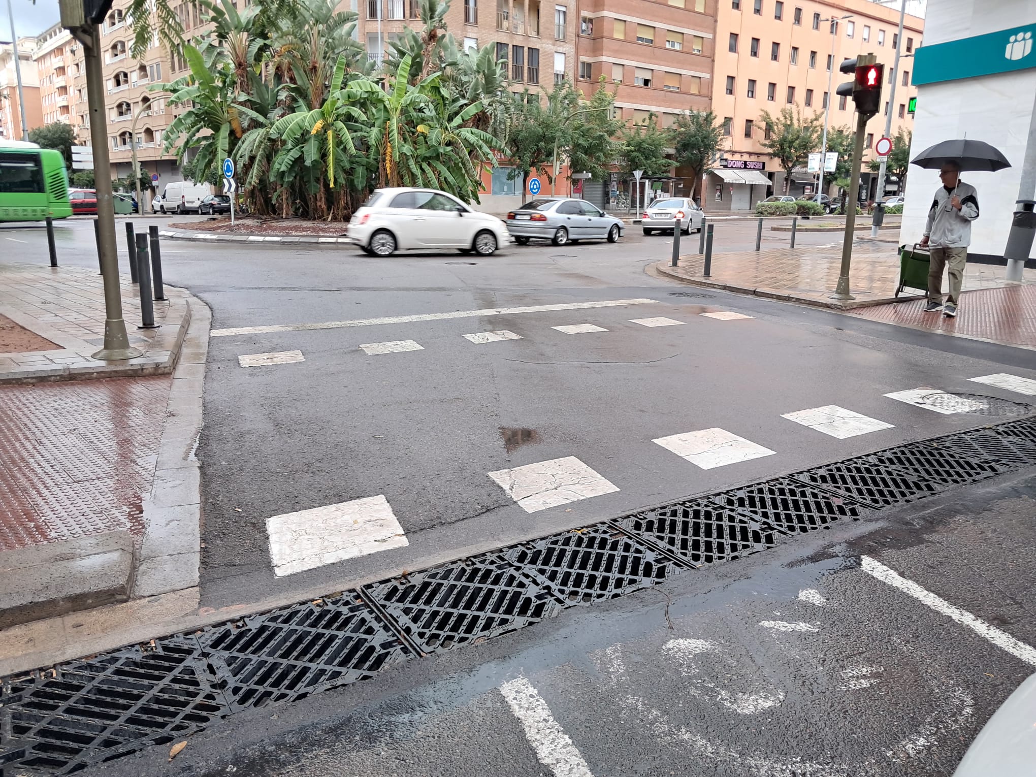 Un hombre cruza un paso de cebra en un día de lluvias en Castellón